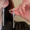 Detail of silver tassel earrings with diamond accents worn by a model in soft light - Zircon Tassel Ear Buckle / Silver