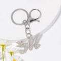 Detail eines silbernen Buchstaben M Schlüsselanhängers mit Strass und Libellen-Anhänger - Stil M / Silber