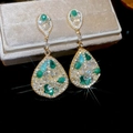Gros plan de boucles d'oreilles vintage dorées avec cristaux verts sur boîte à bijoux - 47# Tige en argent - Or - Vert - Style goutte d'eau