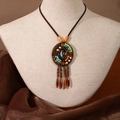 Détail d'un collier ethnique à perles avec pompons sur un buste en lin naturel - X445-1 Style 2