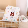 Muslin baby swaddle blanket with forest bear and teepee prints in a storage basket - Big Bear Head