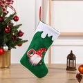 Calcetín navideño verde con gnomo y letra O sobre fondo festivo con accesorios - Letra O / Verde