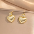 Textured gold heart earrings with zircon studs shown on champagne satin background - Gold (244)