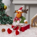 Pluche kerstrendier pop in gebreide outfit op cadeaudoos in een winters sneeuwdecor - Eland Stijl
