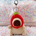 Cute capybara plush keychain wearing a strawberry hat on a colorful bead background - Strawberry Hat Light Brown + Silver Clip