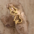 Macro shot of gold heart bee earrings on a natural stone background with high polish finish - EH374-Heart Bee Pendant