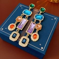 Macro detail of vintage gold earrings with multi-colored gemstones and crystal accents - Multicolor Geometric Gemstone Tassel Style / Colorful
