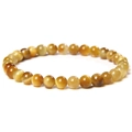 Macro detail of natural tiger eye stone beads with polished texture and cat-eye effect - 6mm Golden Tiger Eye