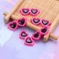 Close-up of five pink heart-shaped resin charms with black lenses for DIY crafts - 28*12mm / Rose Red