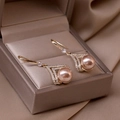 Elegant champagne pearl earrings with gold V-shaped crystal accents on silk fabric - Double V Zirconia Champagne Pearl (A917)