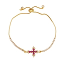 Dettaglio del bracciale dorato con pietre rubino e zirconi brillanti sulla croce - Rosa Rossa