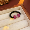 Dettaglio anello di perline nere con fiocco di strass viola su fodera di velluto - Perline Nere Con Fiocco Rosa Viola