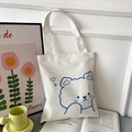 White canvas tote bag featuring a blue cartoon bear print and minimalist shoulder straps - White with Blue Heart Bear