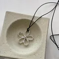 Detalle del colgante de flor plateada con cuentas y cordón negro en bandeja de piedra - Negro (4#)