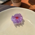 Close-up of a purple acetate flower hair claw clip on an elegant ceramic plate - Pink Purple Flower - Small Claw