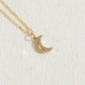 Elegante collana con ciondolo a luna dorata con micro-zirconi su sfondo di pietra ruvida - Medio-Oro