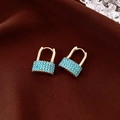 Close-up of golden lock-shaped earrings with inlaid turquoise beads on brown silk - Gold-Blue (Lock Bohemia Style)