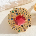 Detail eines Goldrings mit rotem Smaragdschliff-Stein und bunten Zirkonia-Akzenten - Quadratischer Cluster-Stil / Roter Korund Quadratisch
