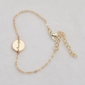 Golden chain bracelet featuring a circular hollow pendant with an engraved letter J - Gold J