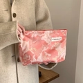 Pink marble pattern makeup bag with woven label held by a hand in a soft studio setting - Chinese Pink