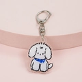 Cute white puppy acrylic keychain with blue floral scarf on a pink display stand - Dog with Scarf