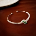 Macro detail of silver snake-shaped open cuff with green marquise stones and zircon paving - Silver Zircon Snake Style (HB1732)