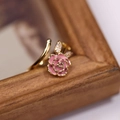 Macro shot of pink rose ring with cubic zirconia leaves against a wooden frame - Adjustable Rose Pink Ring