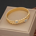 Dettaglio macro del bracciale rigido dorato con malocchio blu su portagioie di lusso - Stile Malocchio Svuotato a Doppio Strato (6#)