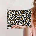 Close-up of leopard print canvas makeup bag with durable black zipper closure in hand - White Gold Leopard Style (jiayingpbb0157)