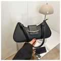 Detail of black matte shoulder bag featuring a gold curved metal buckle and knot strap - Black