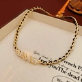 Detalle del collar chapado en oro de 14K con cadena de cuero y camelia de perlas - Estilo Letra Camelia CAH / Dorado