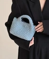 Light blue woven mini bucket bag with knotted handle shown with a black blazer - Haze Blue