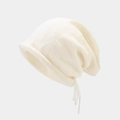 Detalle del gorro de punto crema con borde enrollado y cintas laterales decorativas - M (56-58cm) / Blanco