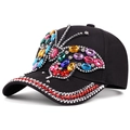 Black baseball cap featuring a large colorful rhinestone butterfly and studded brim - Adjustable / Black
