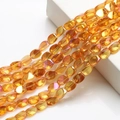 Macro shot of 10x12mm yellow AB crystal beads with faceted finish and rainbow luster - Gold Rose Red