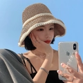 Khaki woven straw bucket hat for women with elegant white pearl trim against a blue sky - M (56-58cm) / Khaki