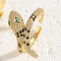 Macro shot of 14K gold snake ring with white and black zircon pavé and green gem eyes - Adjustable Open / Gold Black & White Zirconia