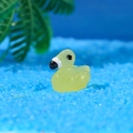 Glow-in-the-dark yellow resin duck miniature for fairy gardens on blue sand - Yellow