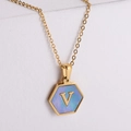 Dettaglio del pendente esagonale in oro con intarsio in conchiglia blu e lettera V - Stile V