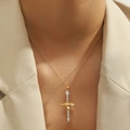 Elegant gold cross sword pendant necklace with zircons worn over a beige blazer - Sword (YSN103GL)
