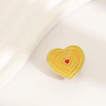 Detail of heart enamel pin with rainbow gradient layers and elegant gold metal trim - Yellow Heart