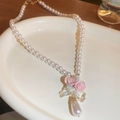 Detailed shot of a sweet floral pearl necklace with pink roses and bow on a white tray - Necklace-White