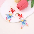 Detailed close-up of handmade beaded doll earrings on white tray with tulip - Red Yellow Blue Style (Picture 2)