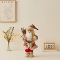 Standing Santa figurine with red knit outfit, wooden skis and basket in cozy home setting - Knitted Red Outfit With Skis / 45cm