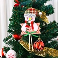 Christmas snowman plush ornament with plaid hat and Feliz Navidad sign on a green tree - Hanging Rope Snowman