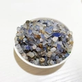 Polished natural crystal stones in blue and white colors displayed in a white ceramic bowl - Blue Agate
