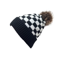 Detail van gebreide muts met dambordpatroon en een pluizige pompon van imitatiebont - Zwart Wit Geblokt