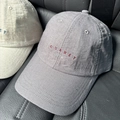 Primer plano de gorra de algodón con bordado JOURNEY y textura de tela transpirable - Gris