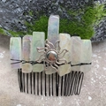 Dettaglio del pettine per capelli in quarzo arcobaleno e sole d'argento su roccia muschiata - Cristallo Bianco Iridescente Filo Nero Sole d'Argento