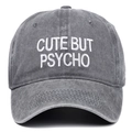 Détail de la broderie CUTE BUT PSYCHO blanche sur une casquette en coton gris délavé - Taille unique / Gris